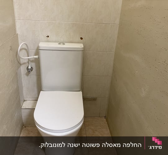 אסלה בחדר שירותים עם קירות מרוצפים